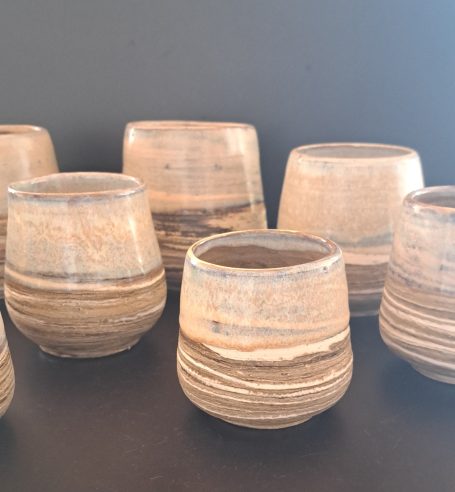 Verschiedene handgefertigte Tontassen mit spiralförmiger Maserung.