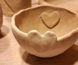 Braune Keramikschale mit herzförmigem Reliefmuster auf der Innenseite.